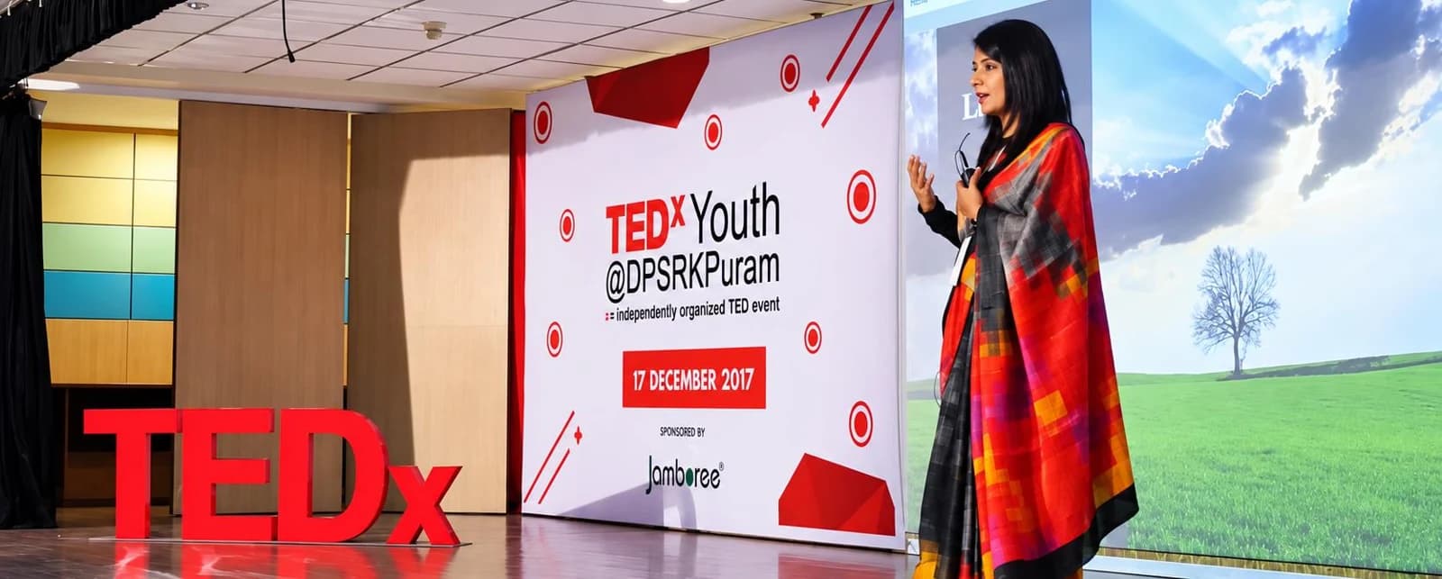 Woman speaking on a TEDx stage